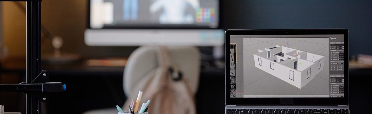 Office desk setup with laptop showing architectural designs and screens in background depicting digital modeling creating focused atmosphere enhancing productivity