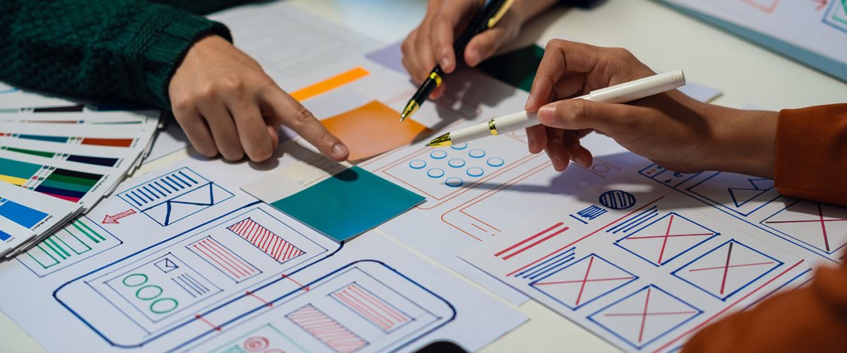 ui designer brainstorming about mobile app interface wireframe design with customer breif and color code at office.